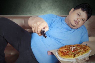 Man eats pizza while watching tv 1 clipart