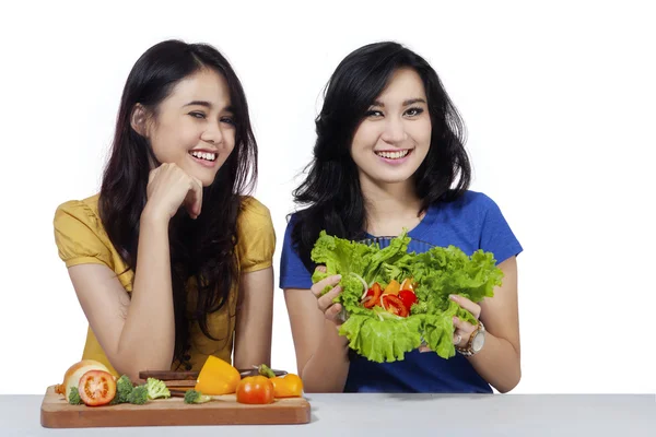 Vänliga flickorna med grönsaker sallad — Stockfoto