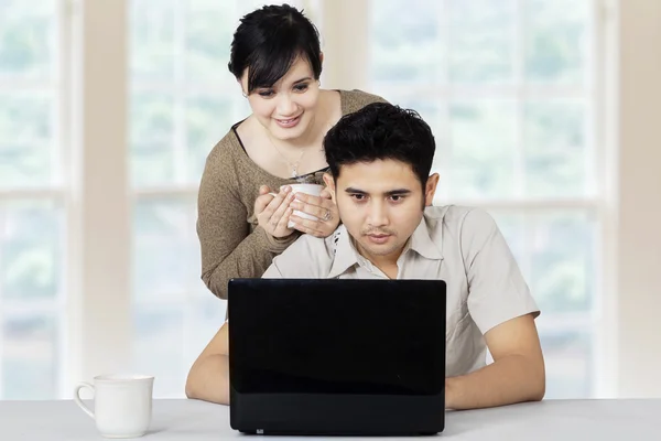 Мужчина с девушкой используют ноутбук дома — стоковое фото