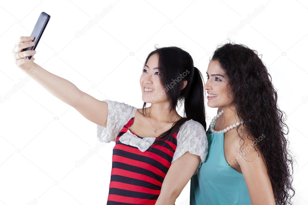 Multi racial girls taking photos in studio