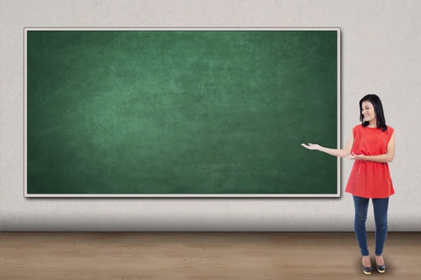 Casual woman showing empty chalkboard — Stock Photo, Image