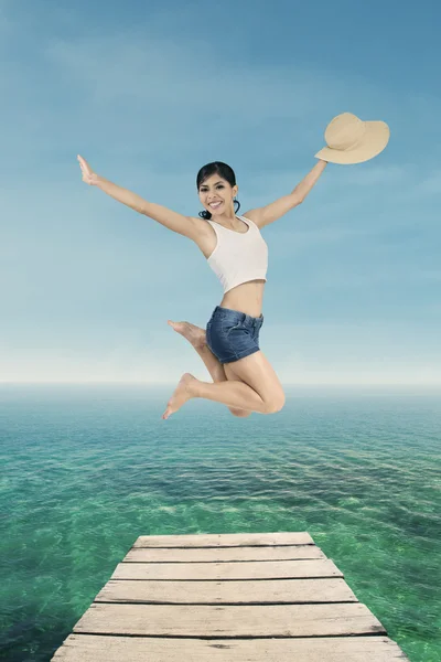 Жінка-туристи стрибають на пірсі — стокове фото