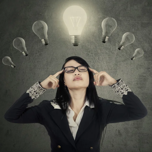 Pretty female manager thinking under lamps — Stock Photo, Image