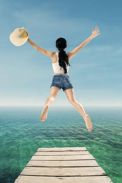 Mujer disfrutar de la libertad por saltar en el muelle — Foto de Stock