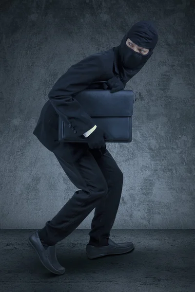 Empresário com máscara roubando uma pasta — Fotografia de Stock