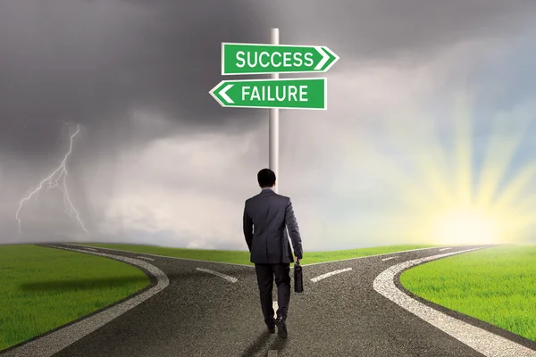 Entrepreneur with signpost to success or failure — Stock Photo, Image