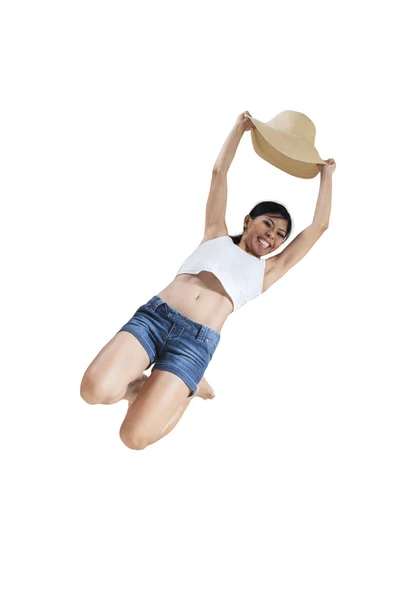 Joyful girl jumping in the studio with hat — Stock Photo, Image