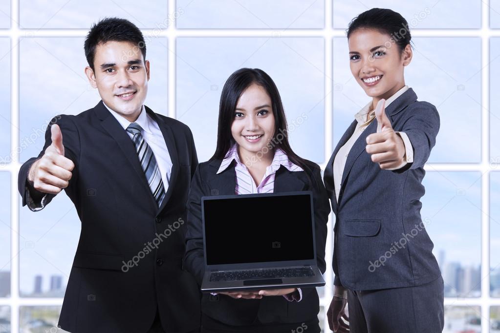 Asian business team showing blank screen on laptop
