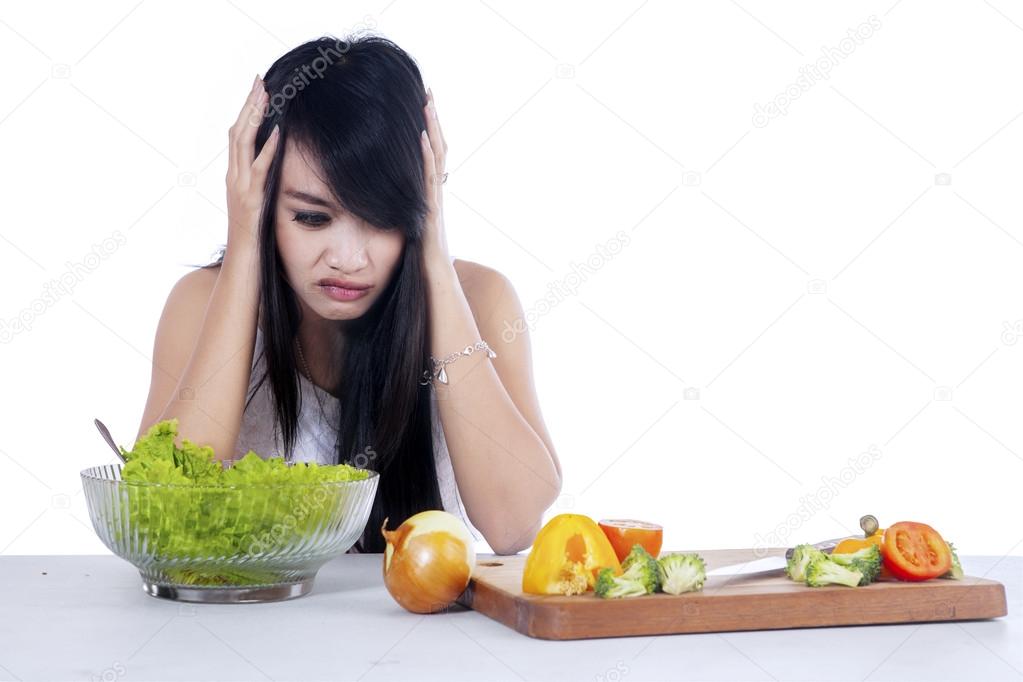 Woman hesitate to eat salad 1
