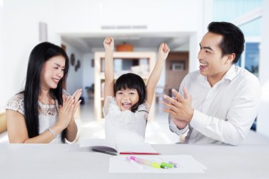 Cheerful girl get appreciation from her parents clipart