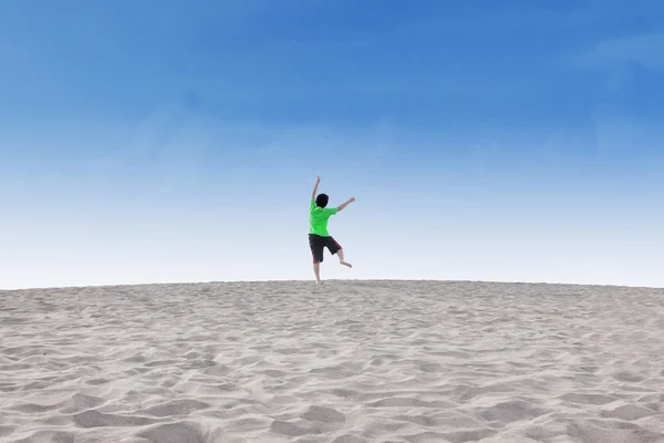 Веселый маленький мальчик прыгает по пустыне — стоковое фото