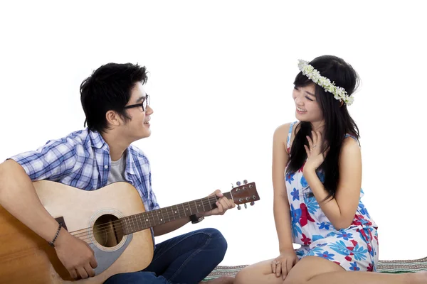 Красавчик играет на гитаре со своей девушкой. — стоковое фото