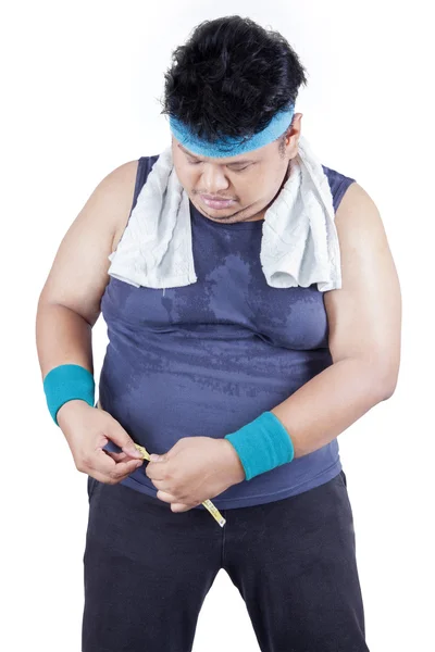 Ожирний чоловік вимірює свою талію — стокове фото