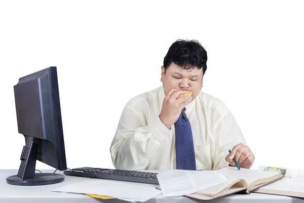 Obese worker reading book on table — Stock Photo, Image