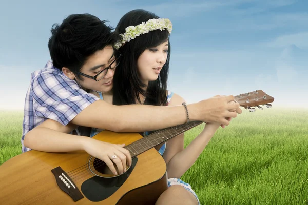 Couple romantique jouant de la guitare sur le terrain — Photo