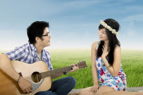 Romântico cara tocando guitarra para sua namorada — Fotografia de Stock