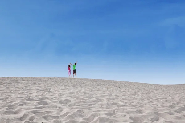 Двое детей прыгают по пустыне — стоковое фото