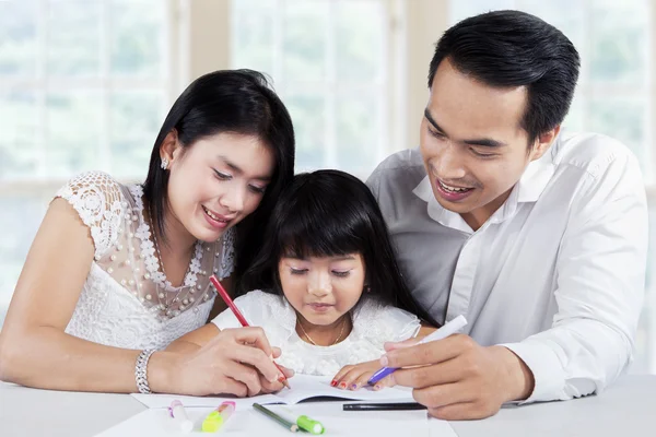 Young family doing schoolwork together — Stock Photo, Image