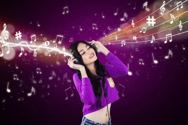 Диджей наслаждается музыкой на фиолетовом фоне — стоковое фото