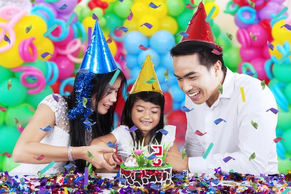 Bambina taglio torta di compleanno con i genitori — Foto Stock