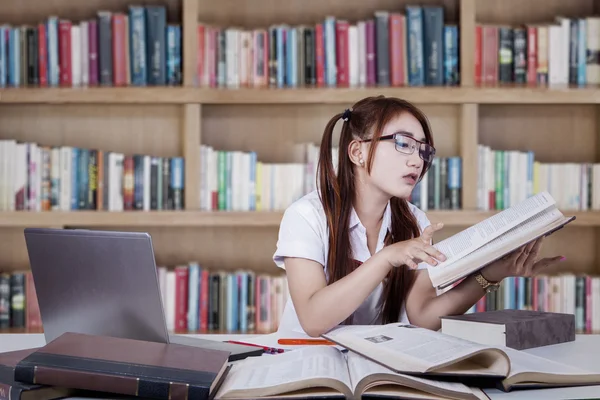 Adolescente segurando e lendo um livro — Fotografia de Stock