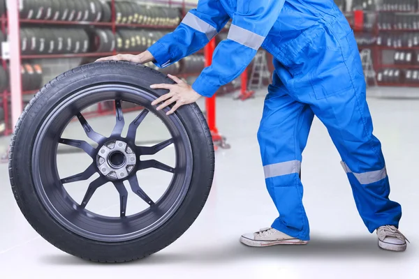 Técnico trocando um pneu na oficina — Fotografia de Stock