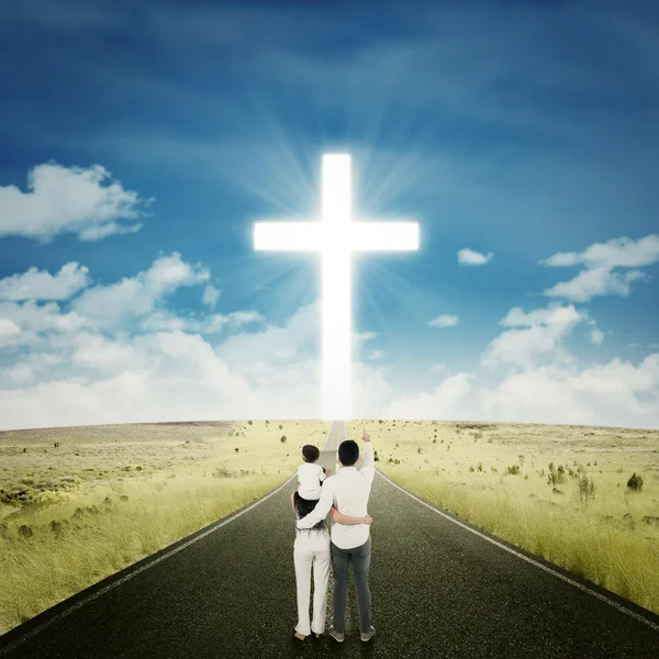 Família feliz na estrada com uma cruz — Fotografia de Stock