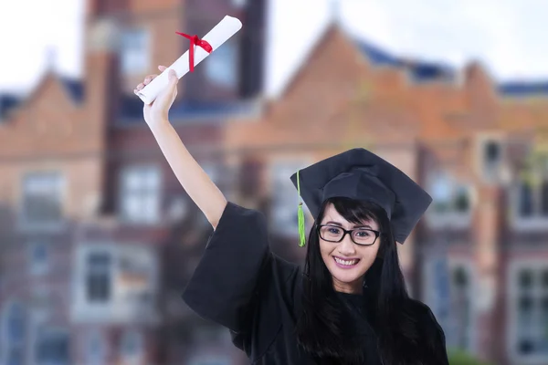 Glückliche Studentin im Abschlusskleid draußen — Stockfoto