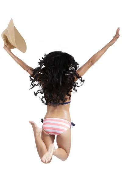 Счастливая женщина в бикини прыгает в студии — стоковое фото