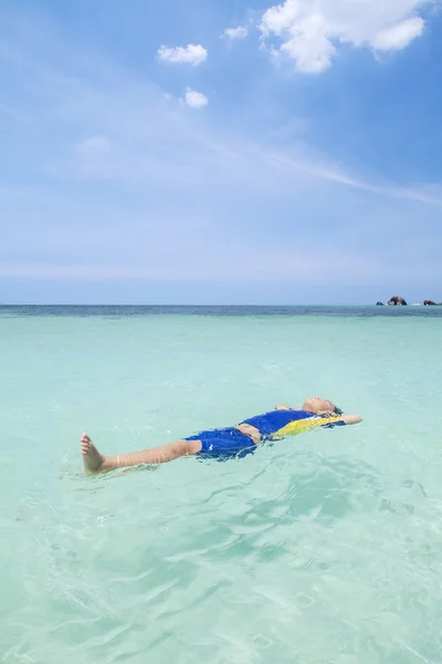 Kleiner Junge schwimmt am Strand — Stockfoto