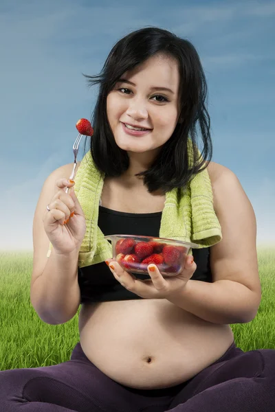 怀孕在户外吃草莓 — 图库照片