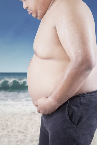 Homem triste olhando para sua barriga gorda — Fotografia de Stock