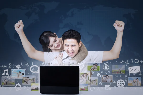 Successful couple with online business on blue world map — Stock Photo, Image