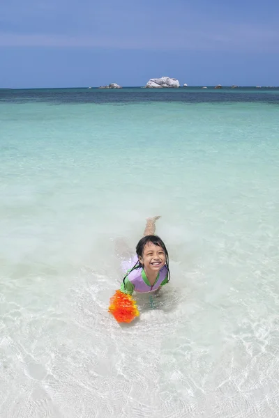 Petite fille joyeuse nageant à la plage — Photo