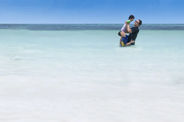 Çocuk ve babası kumsalda eğleniyor — Stok fotoğraf