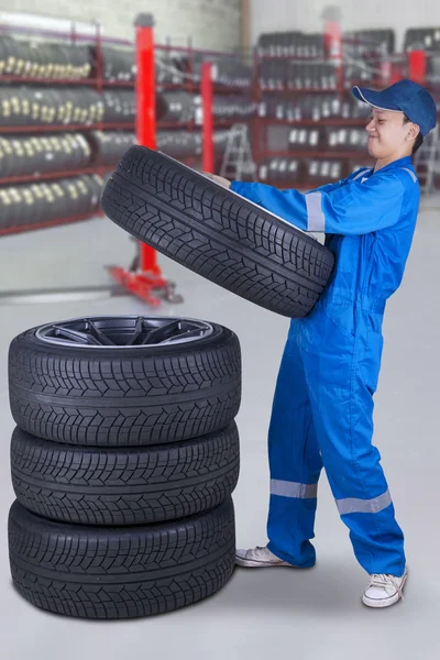 Mécanicien empilant les pneus dans l'atelier — Photo