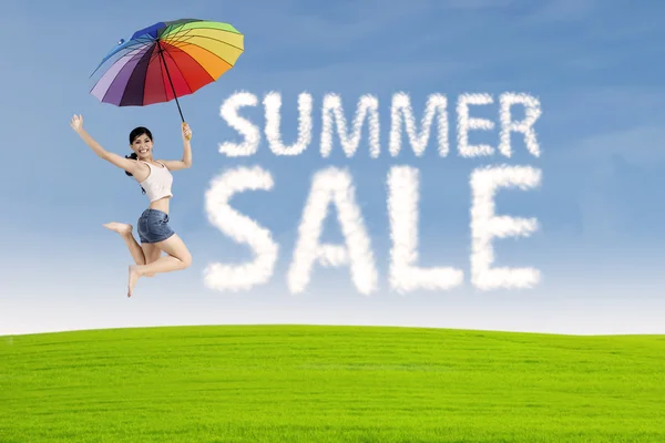 Woman jumps with summer sale sign — Stock Photo, Image