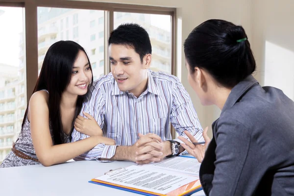 Pareja joven discutiendo con un agente financiero —  Fotos de Stock