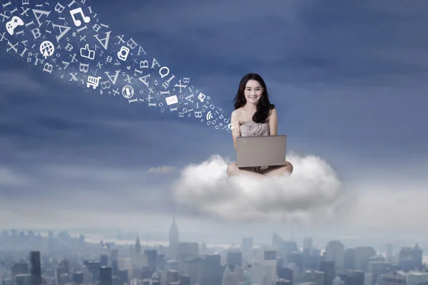 Teenage girl working with laptop on cloud — Stock Photo, Image