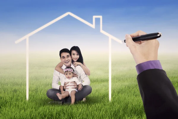 Linda família sentada sob uma casa de sonho — Fotografia de Stock