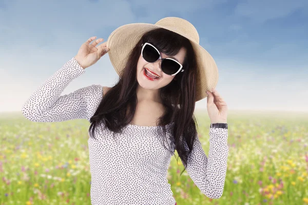 Glada kvinna med solglasögon på ängen — Stockfoto