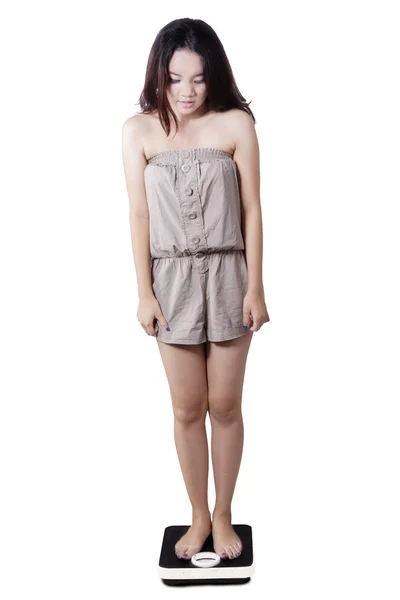 Menina adolescente em pé em escalas de peso — Fotografia de Stock