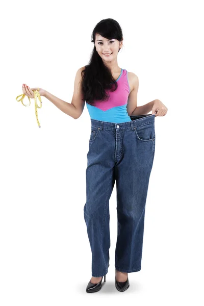 Женщина с измерительной лентой и старыми джинсами — стоковое фото