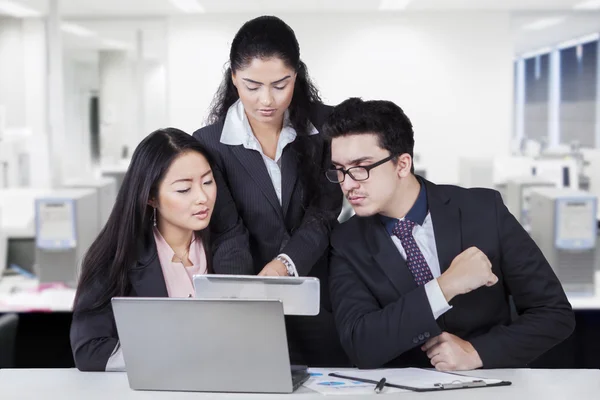 Businesswoman showing tablet at her partners — Stock Photo, Image