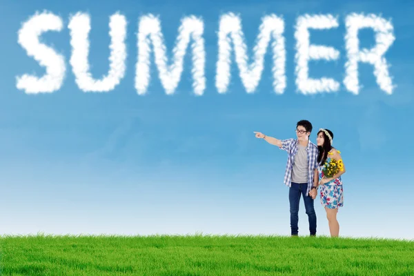 Couple look at cloud shaped summer text — Stock Photo, Image