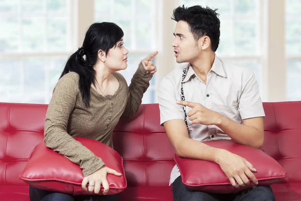 Casal brigando enquanto sentado no sofá — Fotografia de Stock