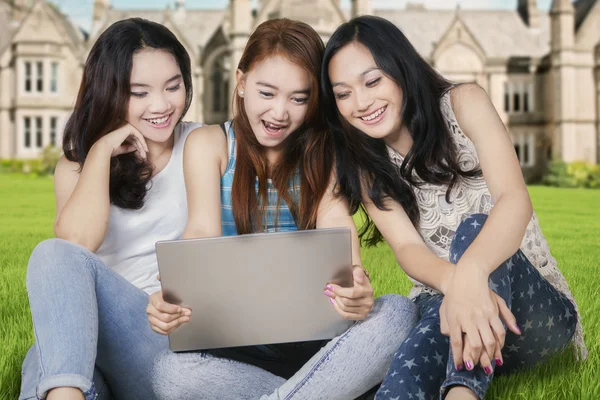 Aufgeregte Schülerinnen mit Laptop auf dem Schulhof — Stockfoto