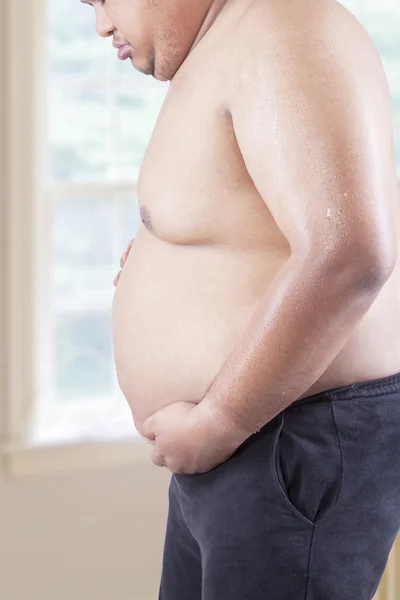 Fat person with big tummy at home — Stock Photo, Image