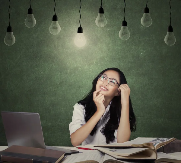 Happy student studying under lightbulb — Stock Photo, Image