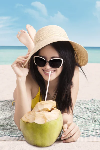 Vrouw met kokos fruit aan kust — Stockfoto